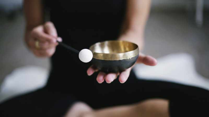 Frau sitzte auf einem Steg am See